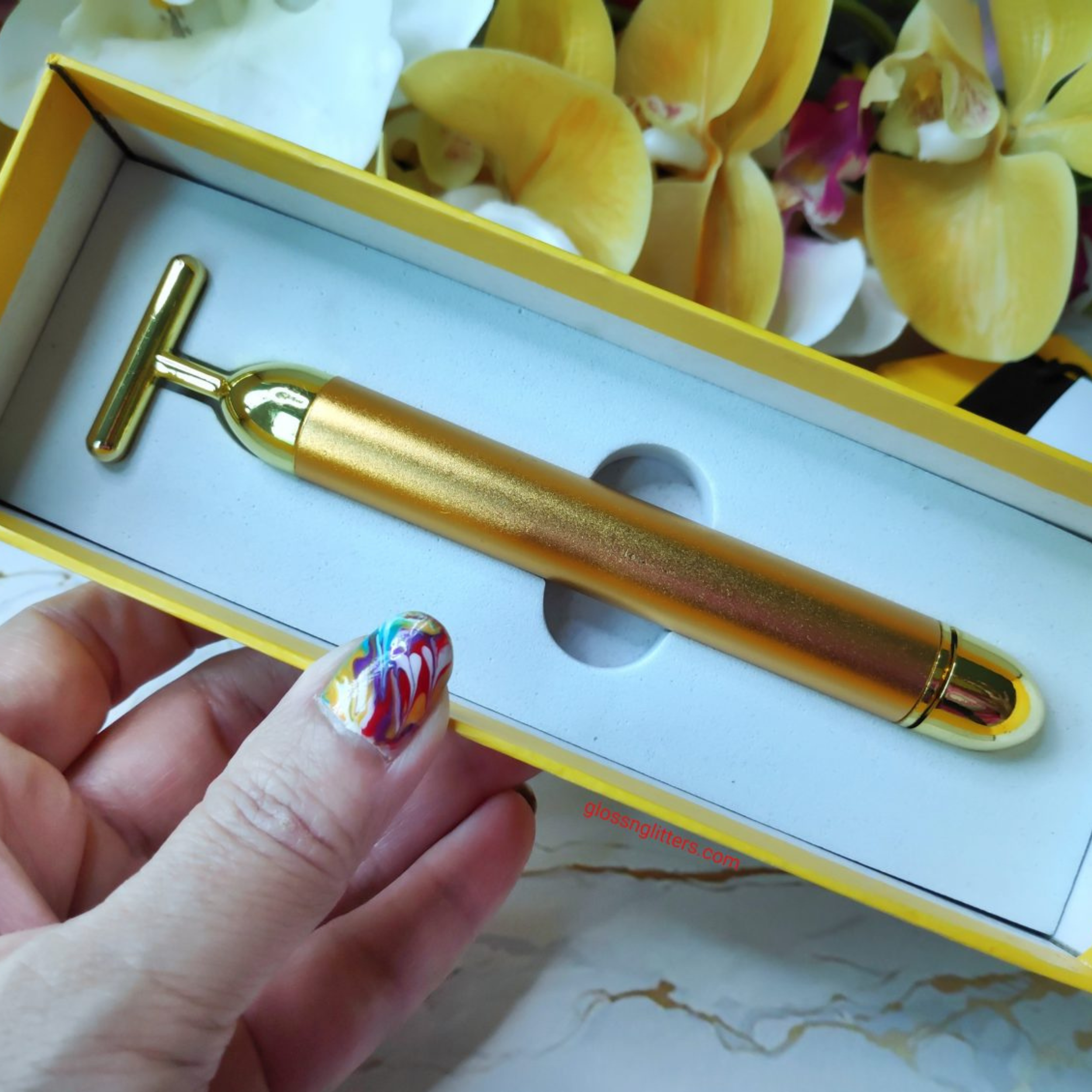 A collection of gold-plated beauty face massager tool. The tools include a roller, a scraper, a spoon, and a ball. The text describes the history and the effects of using gold-plated beauty tools for skincare.